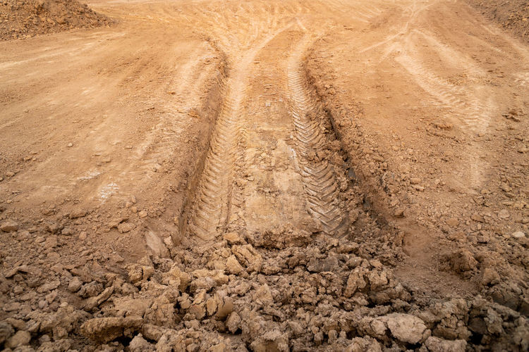 High angle view of tire tracks on dirt road