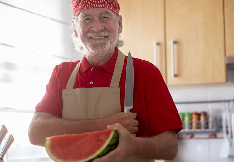 Portrait of smiling man holding watermelon
