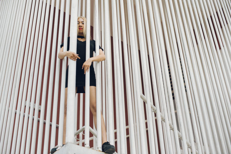 Low angle view of woman standing by railing