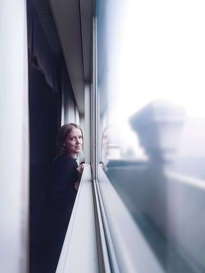 Portrait of woman looking through window at train