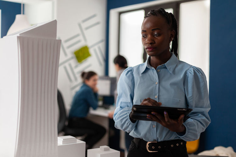 Portrait of young man standing in office