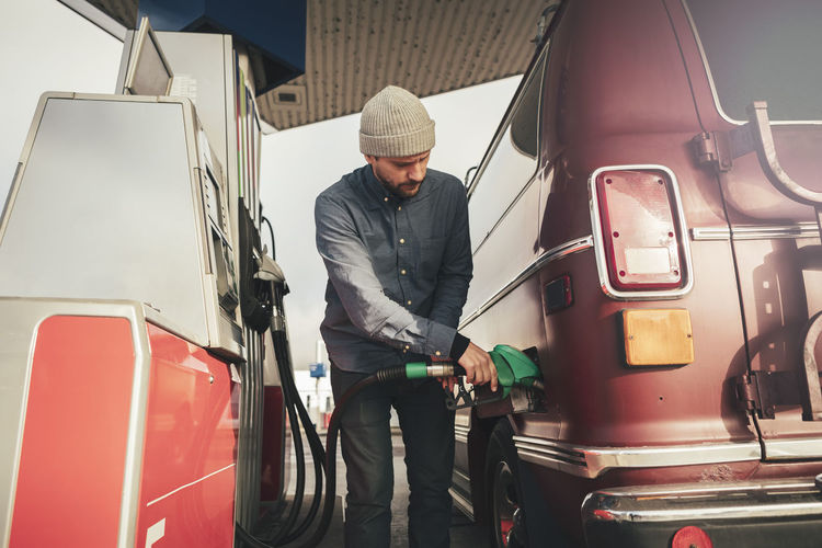 Mature man filling fuel in motor home at gas station