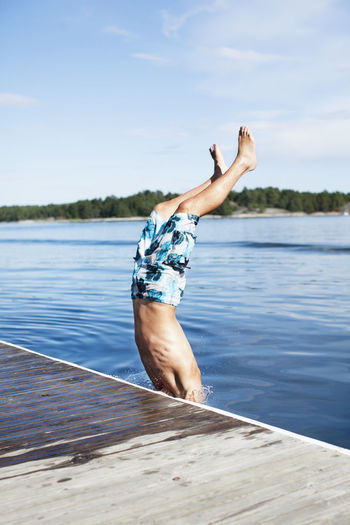 Teenage boy jumping into water