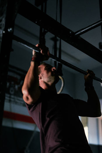 Young man working out in a cage at indoors gym