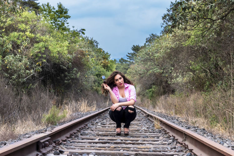 Full length of woman on railroad tracks against sky