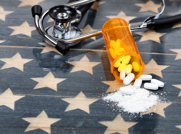 Close-up of pills and stethoscope on american flag