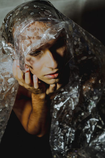 Close-up of young man sitting with plastic