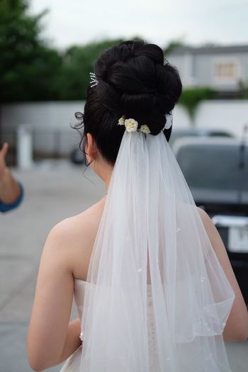 Rear view of bride standing in parking lot