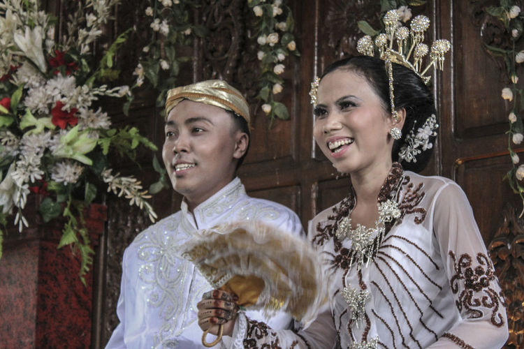 Close-up of groom and bride looking away