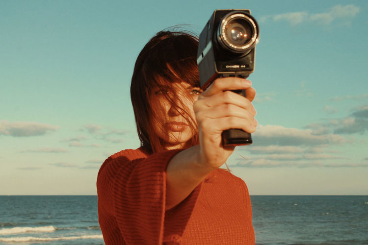 Man photographing with camera against sky