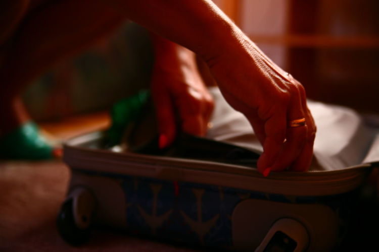 Close-up of woman packing suitcase