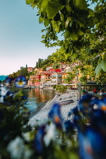 Panoramic view of the village of varenna on lake como with colorful flowers in the foreground