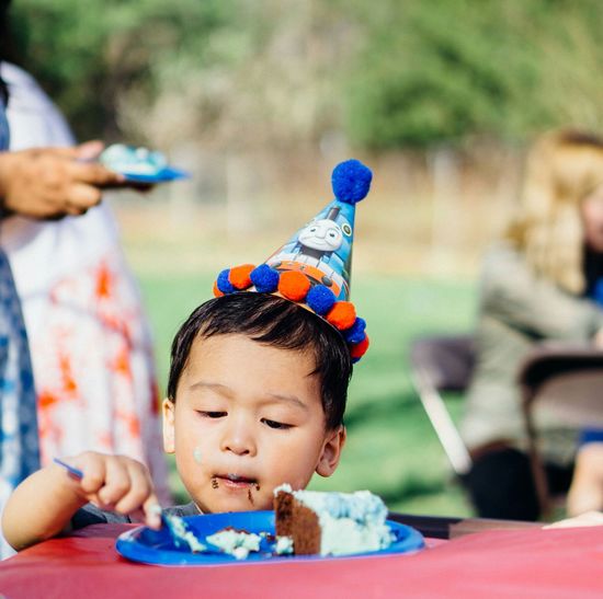 Boy in party hat eating cake