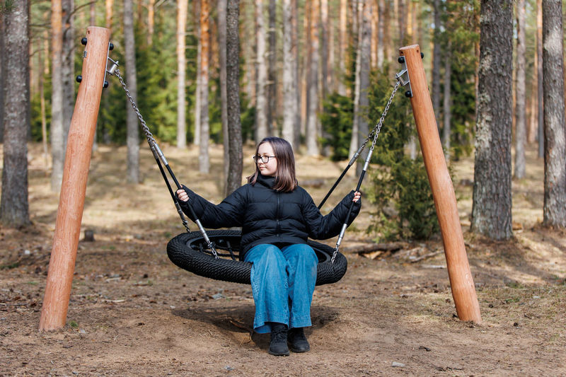 Rear view of woman sitting on swing at playground
