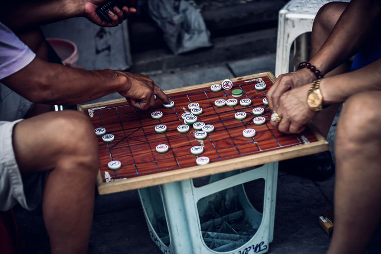Cropped image of men playing board game