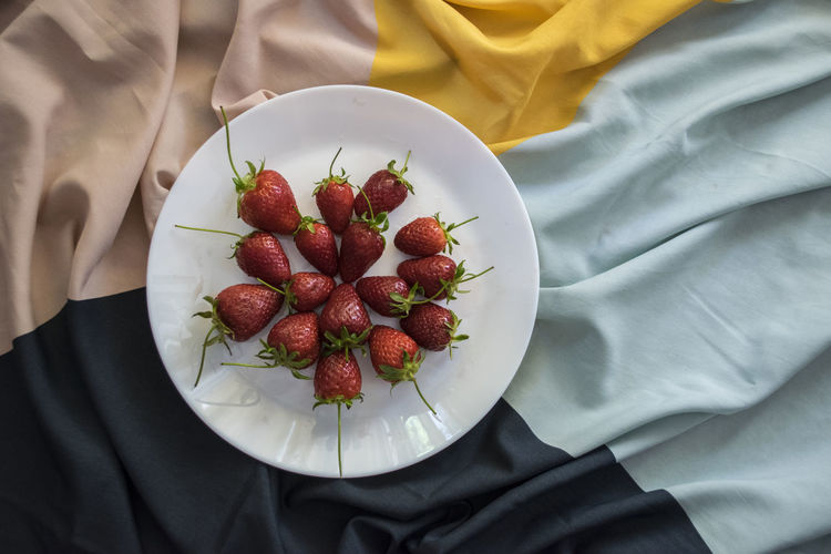 High angle view of strawberries in bowl on bed