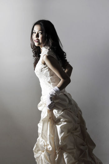 Portrait of bride standing against gray background