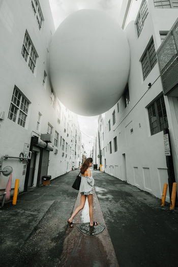 Rear view of woman with umbrella standing in building