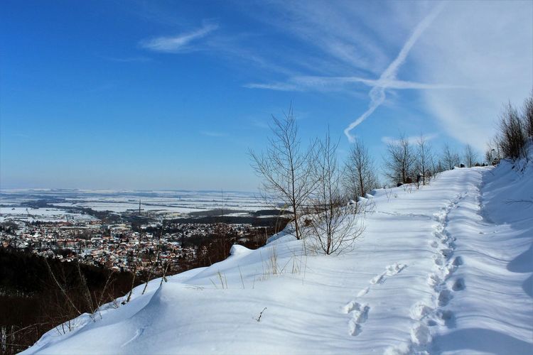 Scenic view of snow covered landscape against blue sky