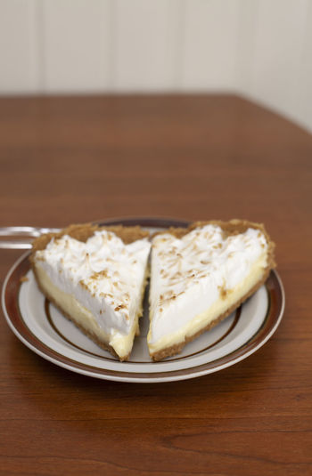 Two slices of lemon meringue pie on plate