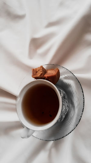 Portrait showing a cup of tea and brown sugar. typical traditional.