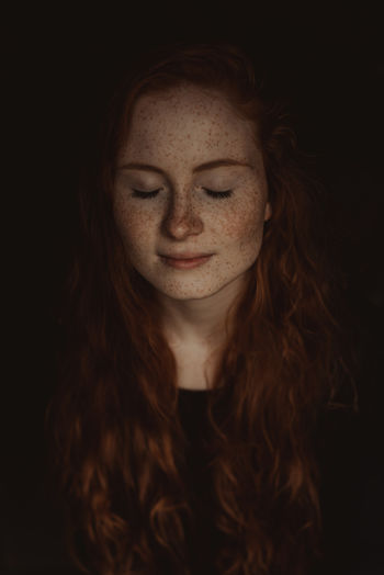 Adult Beautiful Woman Beauty Black Background Close-up Day Eyes Closed Freckle Headshot Long Hair One Person One Young Woman Only Outdoors People Portrait Real People Redhead Smiling Studio Shot Young Adult Young Women