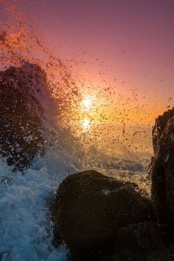 Close-up of sea against clear sky during sunset
