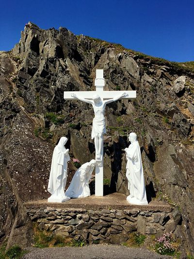 Jesus christ statue on cross against mountain