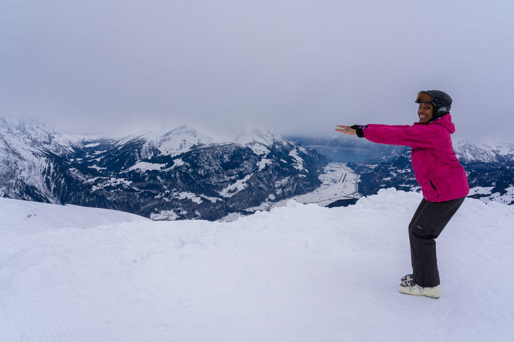 Portrait of woman standing on snowcapped mountain