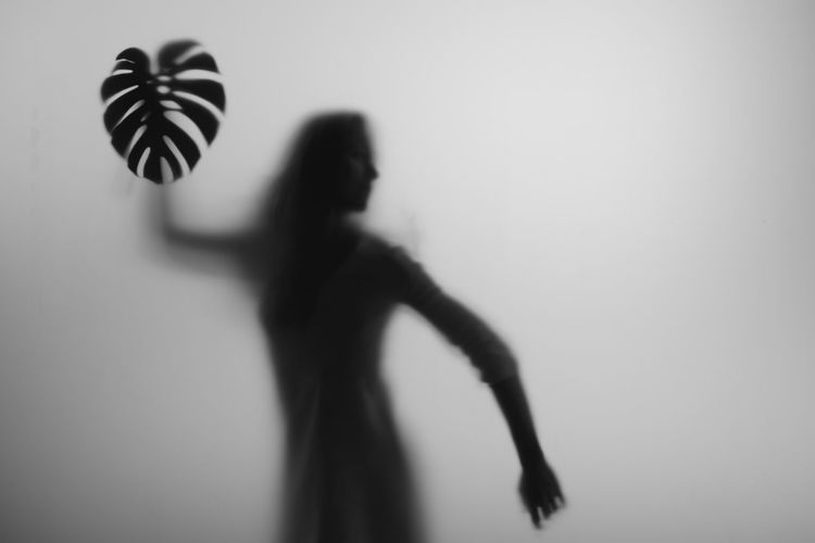Silhouette woman standing against wall