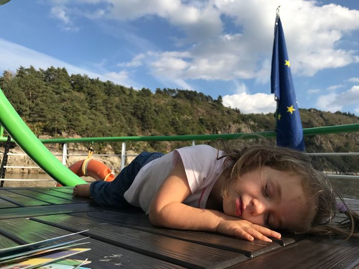 Cute girl sleeping on boat in sea