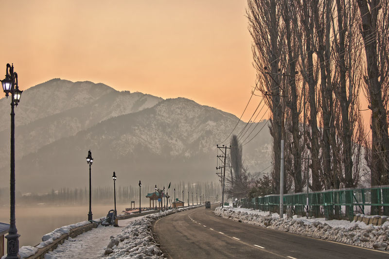 Road by snow covered mountains against sky during sunset, srinagar kashmir 2021