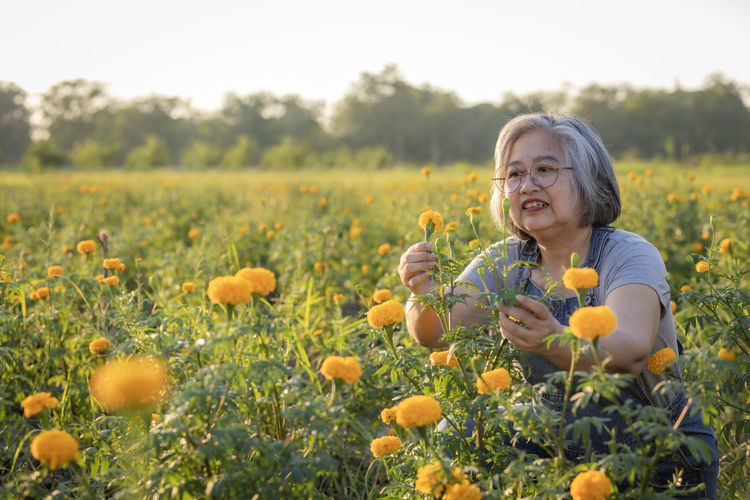 Portrait of smiling young woman picking flowers