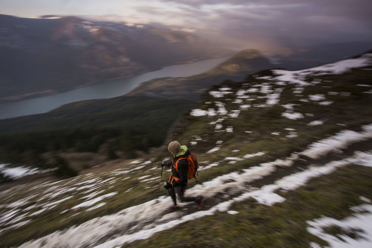 Rear view of person walking on snowcapped mountain