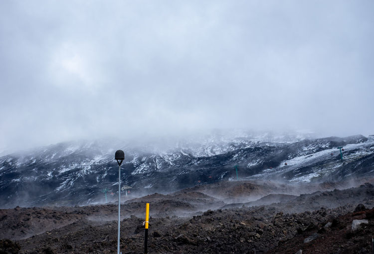 Scenic view of snow covered mount etna, sicily, against foggy sky