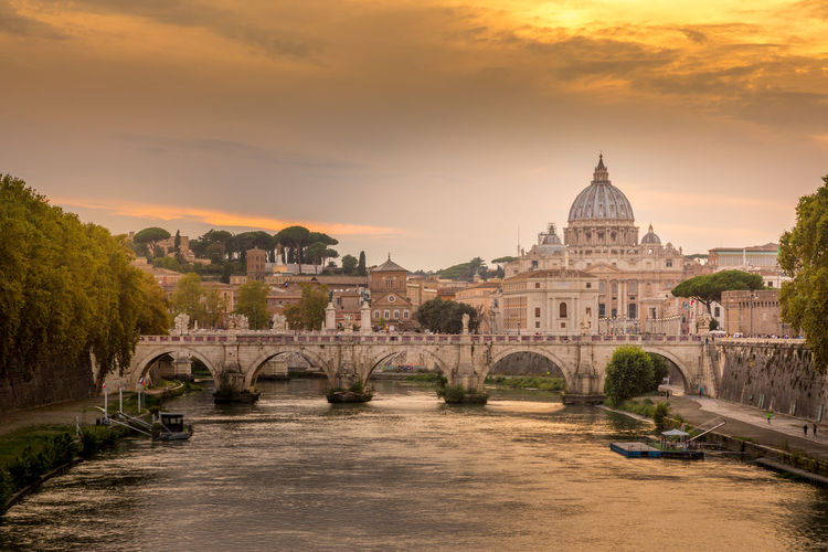 Ponte sant angelo over tiber river during sunset in city
