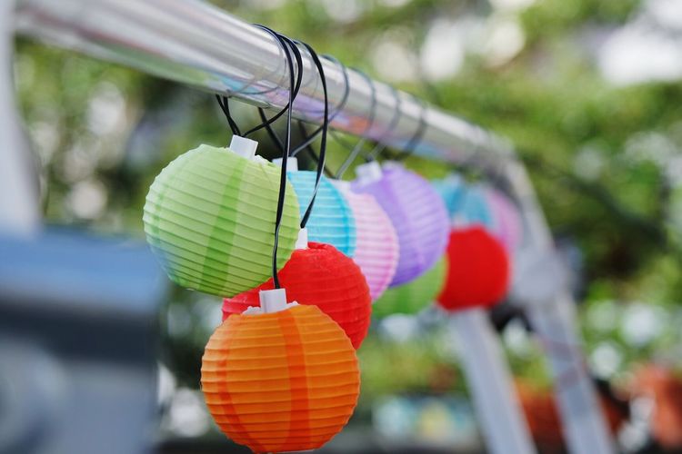 Close-up of multi colored lighting decoration hanging from metal rod