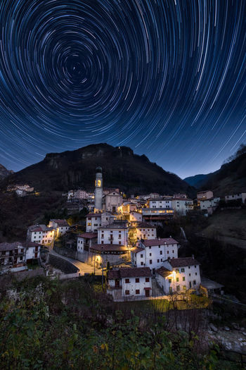 High angle view of illuminated buildings against light trails at night