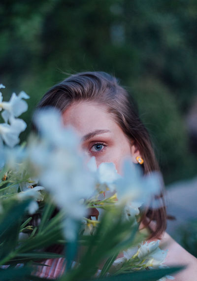 Portrait of woman behind flowering plant