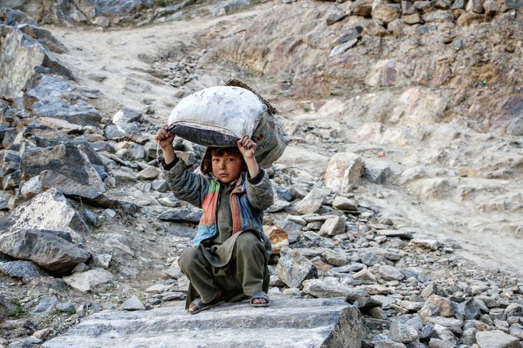 Portrait of boy sitting on rock