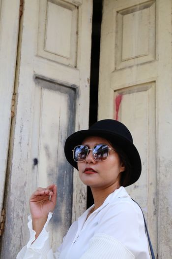 Side view of woman wearing sunglasses and hat