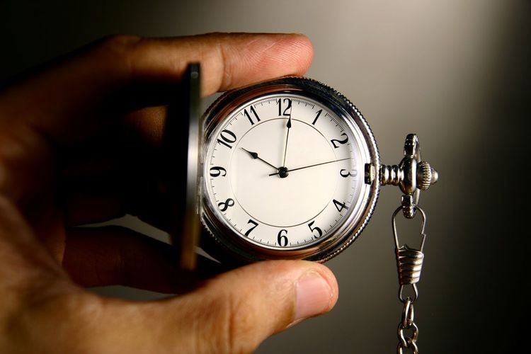 Cropped image of hand holding pocket watch