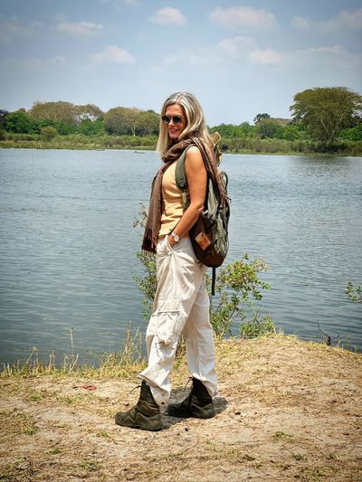 Portrait of young woman standing against lake