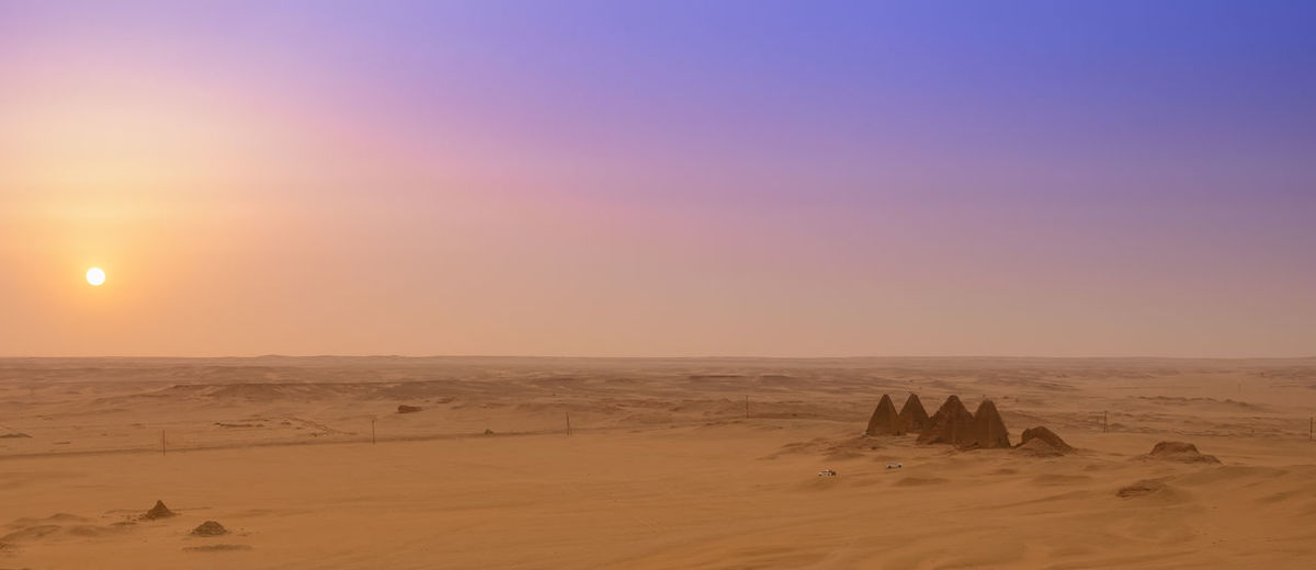Scenic view of desert against sky during sunset