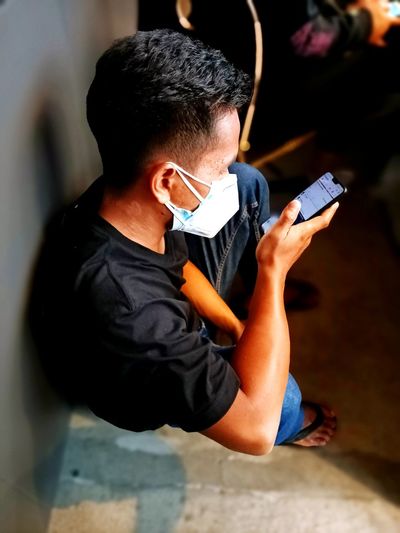 Young man using mobile phone on land