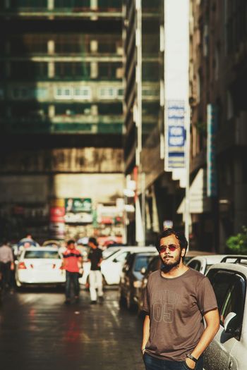 Man standing by car on street