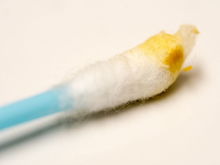 Close-up of dirty cotton swab on white background