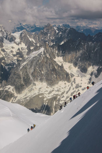 High angle view of people climbing snowcapped mountain