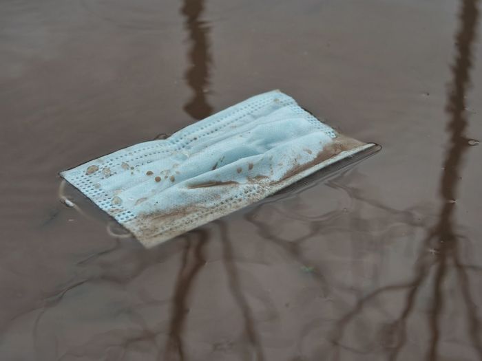 Medical mask lying in puddle