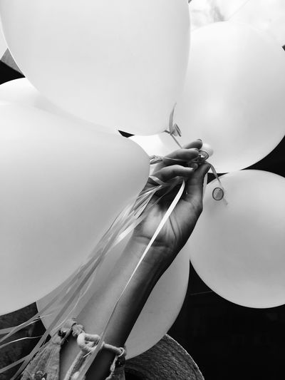 Cropped hand of woman holding balloons